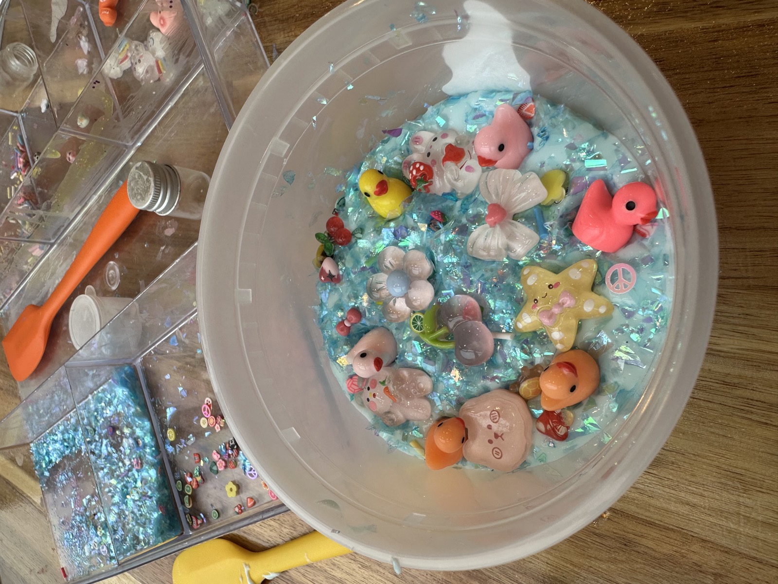 A bowl of custom blue slime filled with charms and glitter