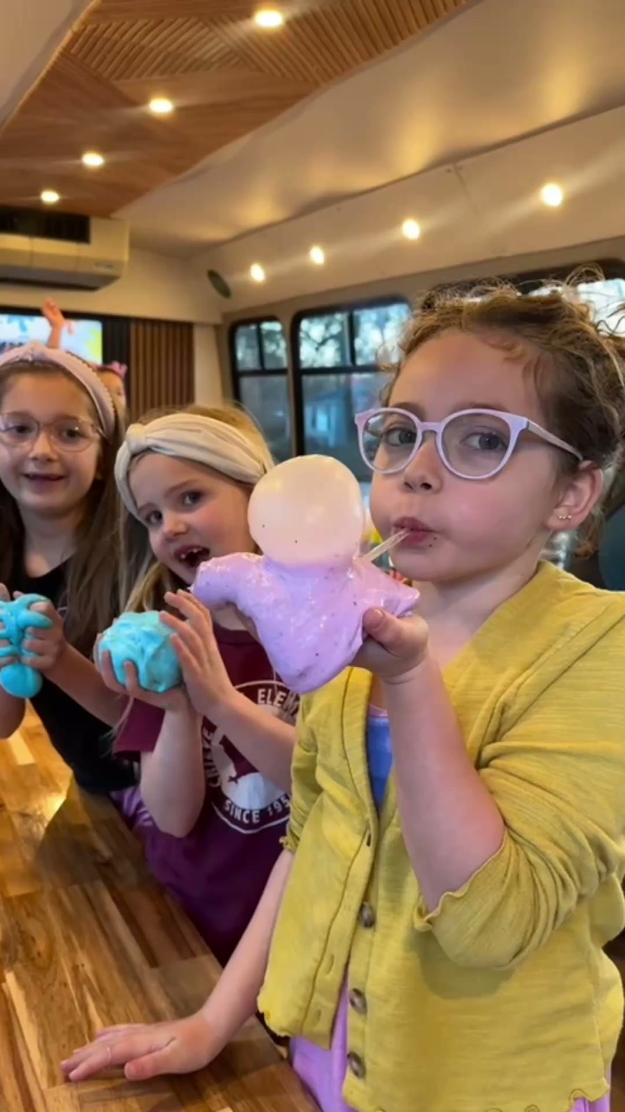 Kids holding their custom slime creations at the Slime Bar